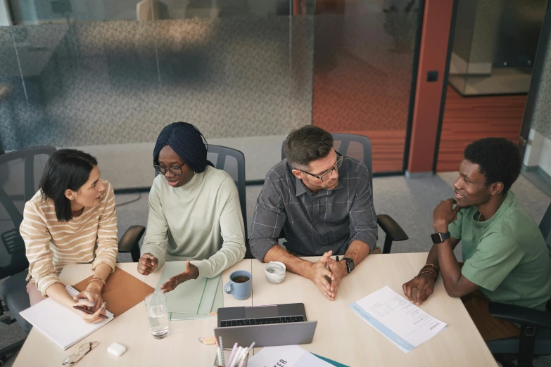 a group of people sitting around a table, on desk