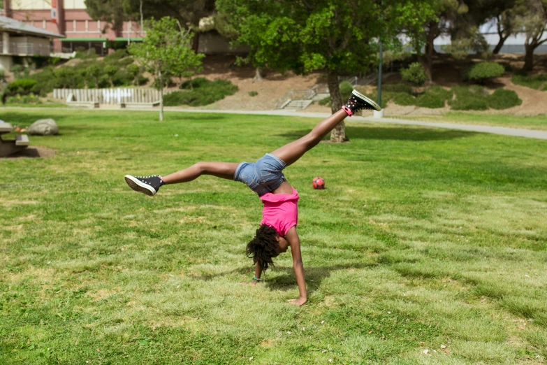 a young girl doing a handstand in a park, by Michael Goldberg, game, riyahd cassiem, los angeles 2 0 1 5, shot on sony a 7 iii