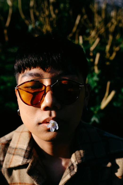 a man with sunglasses and a cigarette in his mouth, an album cover, inspired by Zhu Da, unsplash, pan ren wei, androgynous person, photo 50mm, (golden hour)