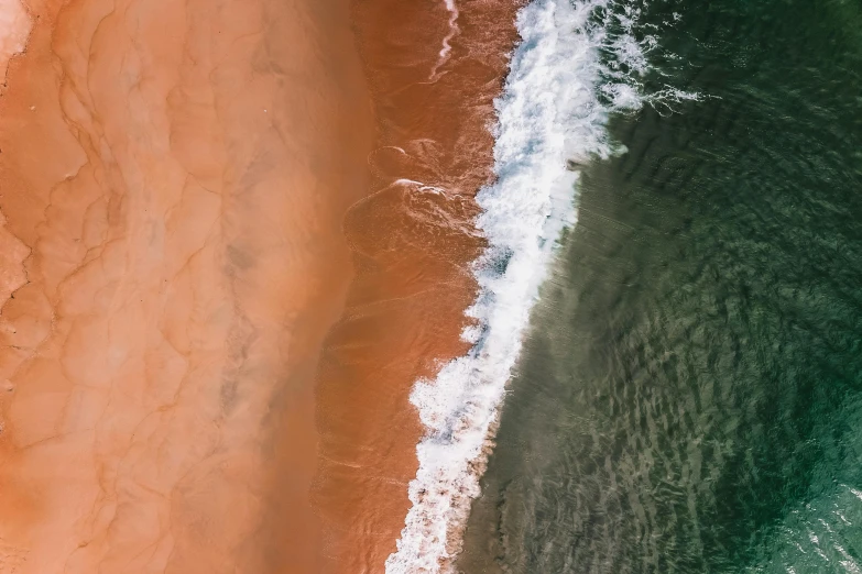 a person riding a surfboard on top of a sandy beach, by Daniel Lieske, pexels contest winner, conceptual art, flowing salmon-colored silk, view from above on seascape, south african coast, two colors