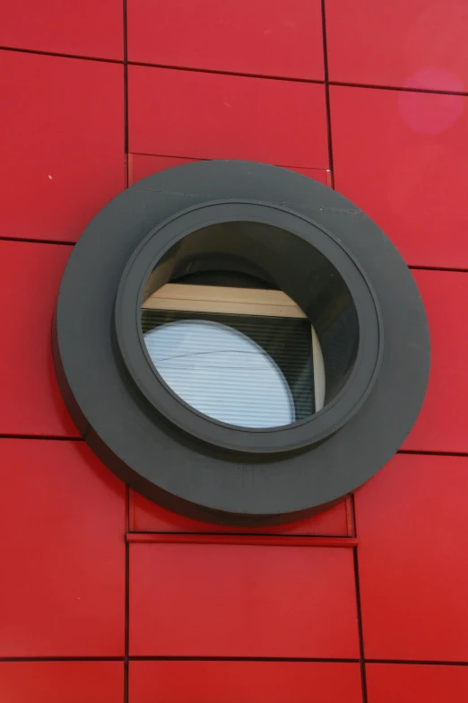 a round window on the side of a red building, coper cladding, 8 0 mm focal, truncated snout under visor, eka's portal