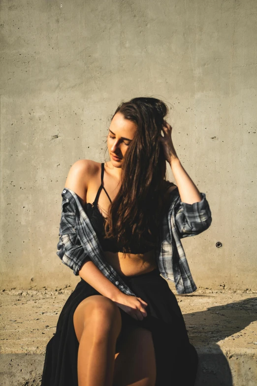 a woman sitting on top of a cement wall, trending on pexels, wearing a sexy cropped top, wearing a flannel shirt, profile pic, wearing black camisole outfit