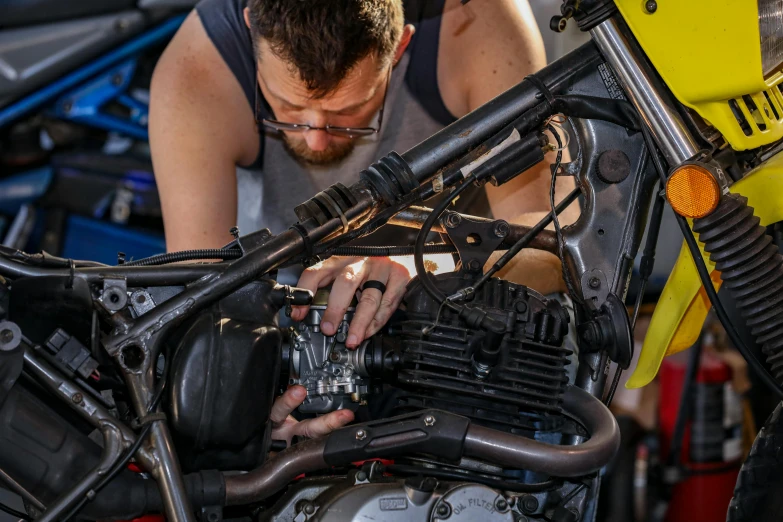 a man working on a motorcycle in a garage, pexels contest winner, starting engines nitro jet drive, lachlan bailey, made from mechanical parts, profile pic