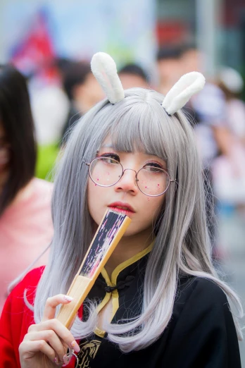 a woman with grey hair and glasses eating a donut, by Kanbun Master, reddit, festivals, lalisa manobal, ethnicity : japanese, drooping rabbity ears