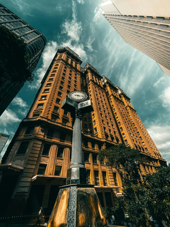 a clock on a pole in front of a tall building, inspired by Sydney Prior Hall, pexels contest winner, fisheye lens photo, buenos aires, thumbnail, golden towers