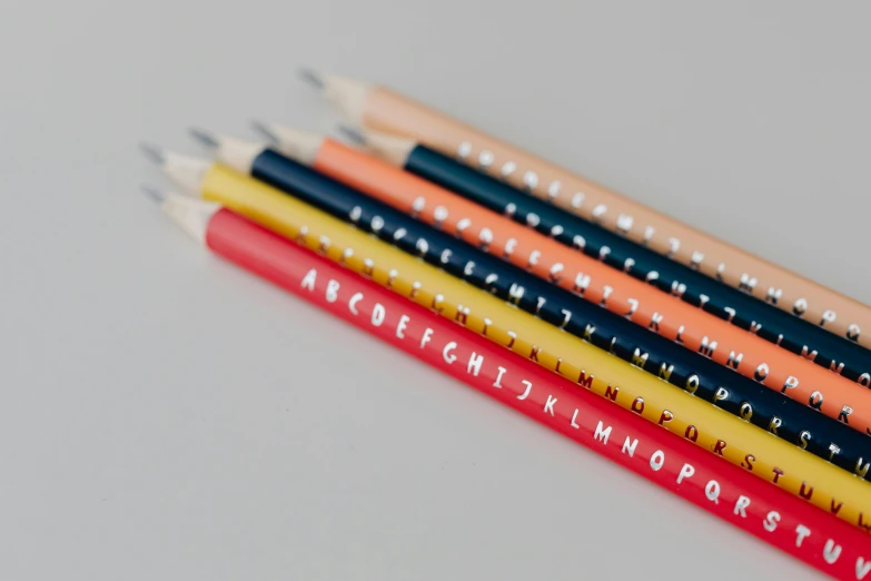 a group of pencils sitting on top of each other, by Maria Johanna Görtz, letterism, multicolor, official product photo, navy, eva elfie