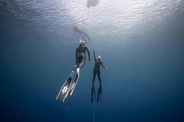 a couple of people that are swimming in the water, bottom of ocean