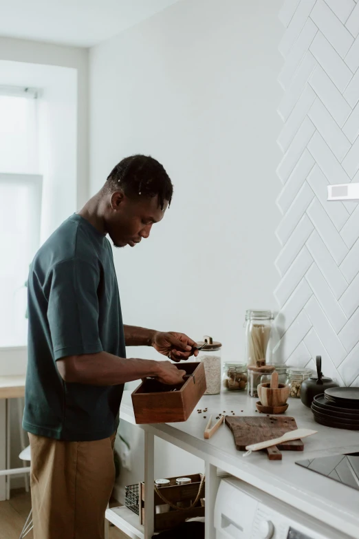 a man standing in a kitchen preparing food, pexels contest winner, black man, professional woodcarving, programming, avatar image
