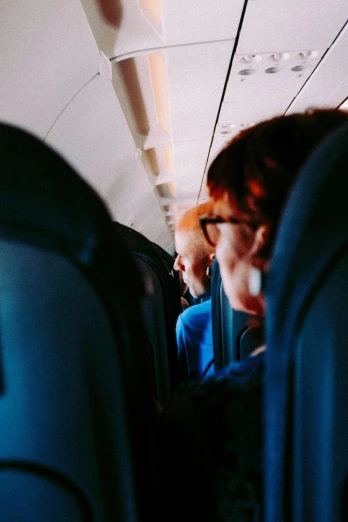 a man talking on a cell phone while sitting in an airplane, by Jessie Algie, pexels, happening, overexposed sunlight, a group of people, backfacing, instagram story