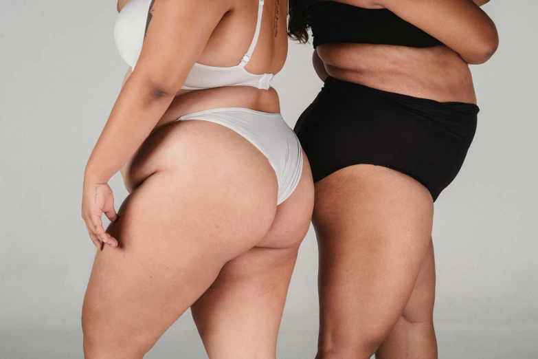 a couple of women standing next to each other, buttshape, product shot, cheeks, white and black