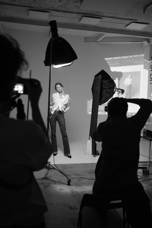 a black and white photo of two people in a studio, a black and white photo, flickr, fashion color studio lighting, peter hurley, various poses shooting photos, action pose : : spotlight