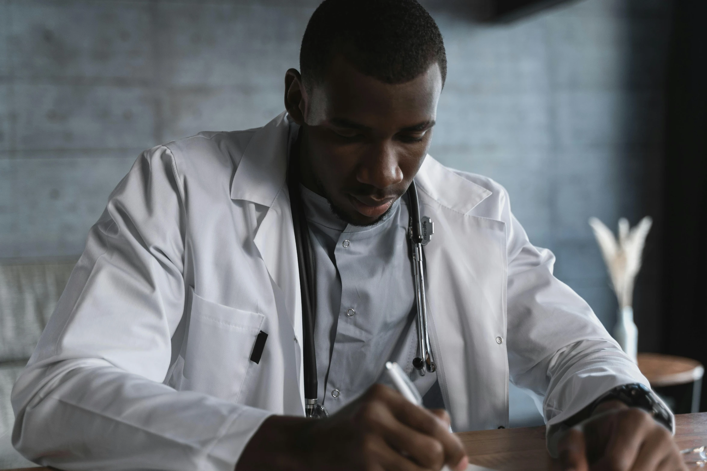 a man in a lab coat writing on a piece of paper, pexels contest winner, hyperrealism, african american, medical labels, a wooden, black