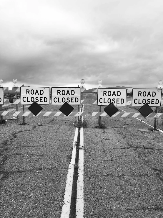 a row of road closed signs sitting on the side of a road, a black and white photo, by Ryan Pancoast, 2 5 6 x 2 5 6 pixels, closed ecosystem, holding close, 4k