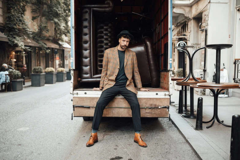 a man sitting on the back of a moving truck, pexels contest winner, renaissance, old wool suit, eng kilian, with furniture overturned, reza afshar