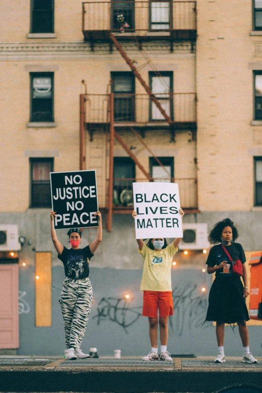 a group of people holding signs in front of a building, trending on unsplash, black arts movement, 3 - piece, peace, brooklyn, summer night