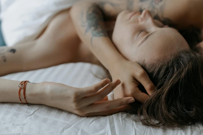 a beautiful young woman laying on top of a bed, a tattoo, inspired by Elsa Bleda, trending on pexels, lesbian embrace, soft smooth skin, gif, bedhead