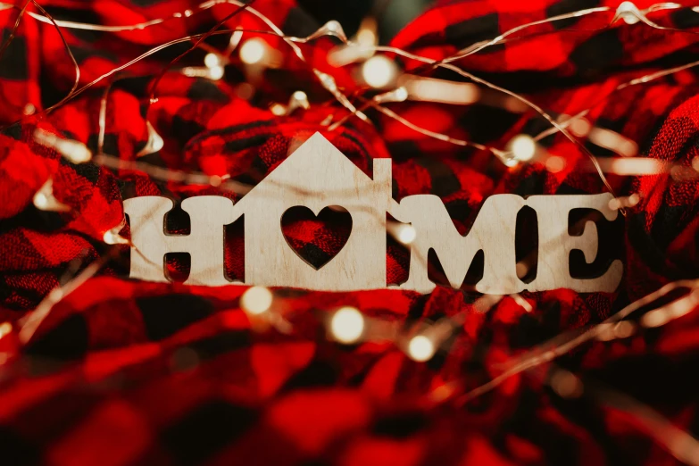 a home sign sitting on top of a red blanket, by Julia Pishtar, pexels contest winner, laser cut, glitter, christmas night, full frame image