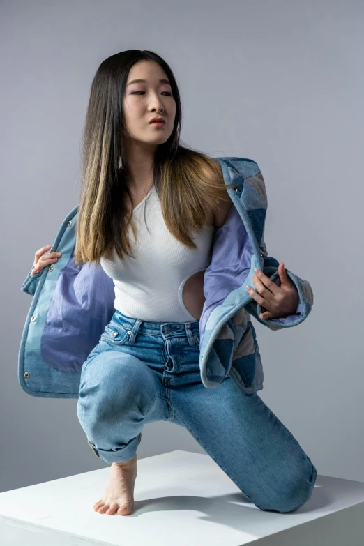 a woman standing on top of a white box, an album cover, inspired by helen huang, trending on pexels, wearing a jeans jackets, open jacket, pokimane, ( ( ( wearing jeans ) ) )