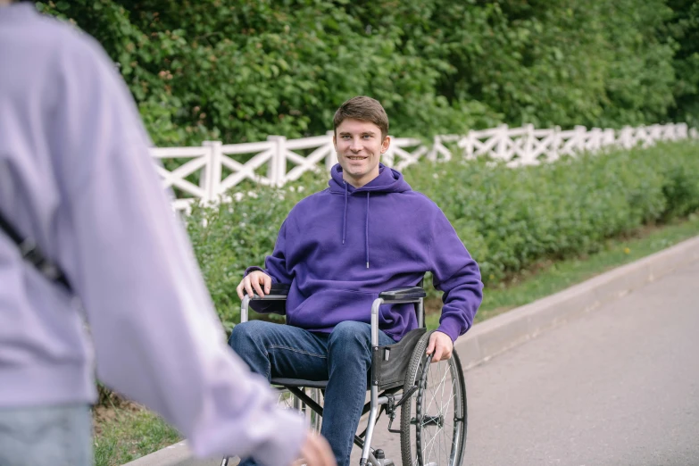 a man in a purple hoodie is in a wheelchair, background image, avatar image, outdoor photo, luka mivsek