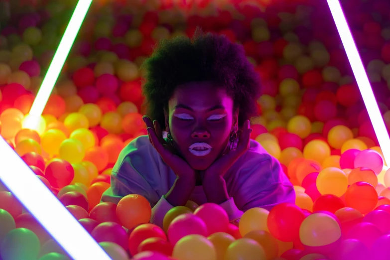 a person laying in a ball pit with neon lights, inspired by Elsa Bleda, pexels contest winner, afrofuturism, black young woman, instagram photo, hyperealistic photo, close up portrait photo