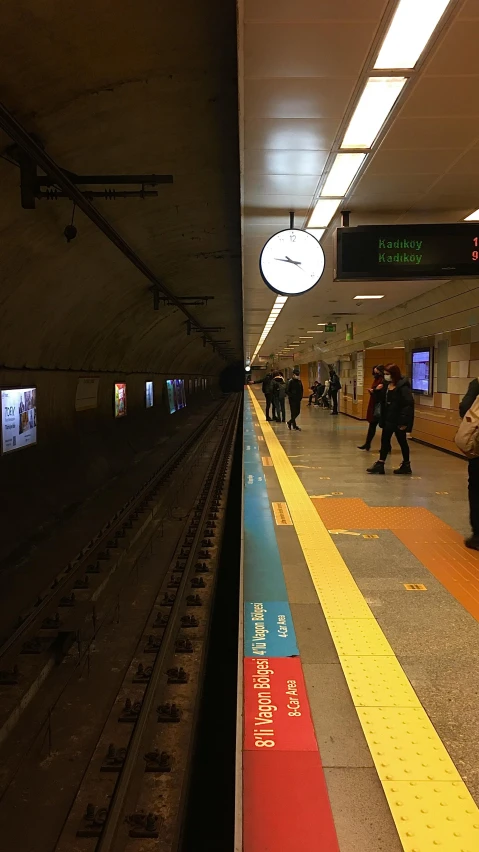 a train station with people waiting on the platform, an album cover, unsplash, chilean, underground metro, cupertino, long view