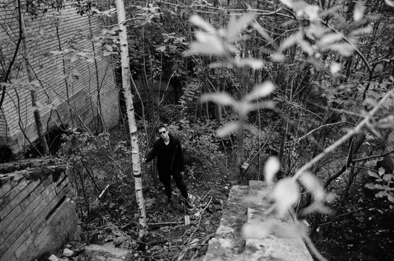 a black and white photo of a man in the woods, berghain, press shot, shot from above, liam