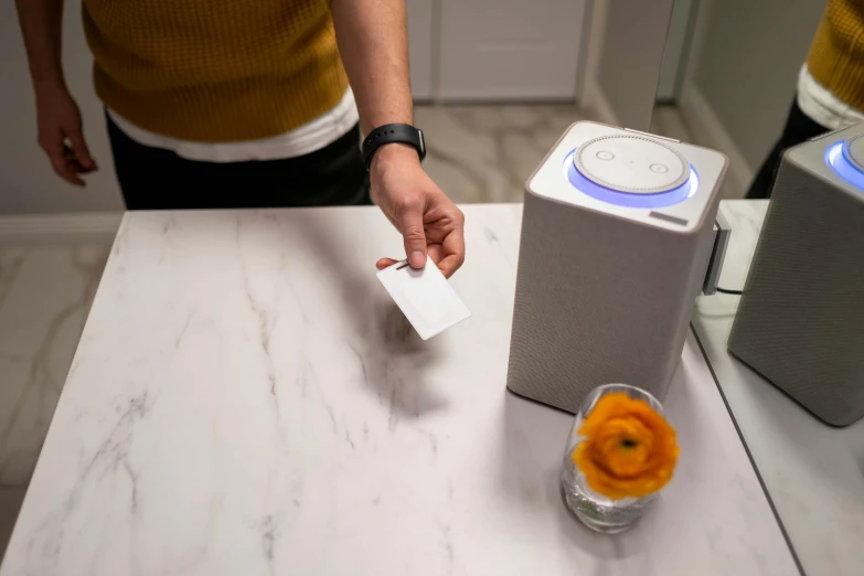 a person putting a card in a box on a table, a hologram, speakers, on a marble pedestal, lossless, next gen