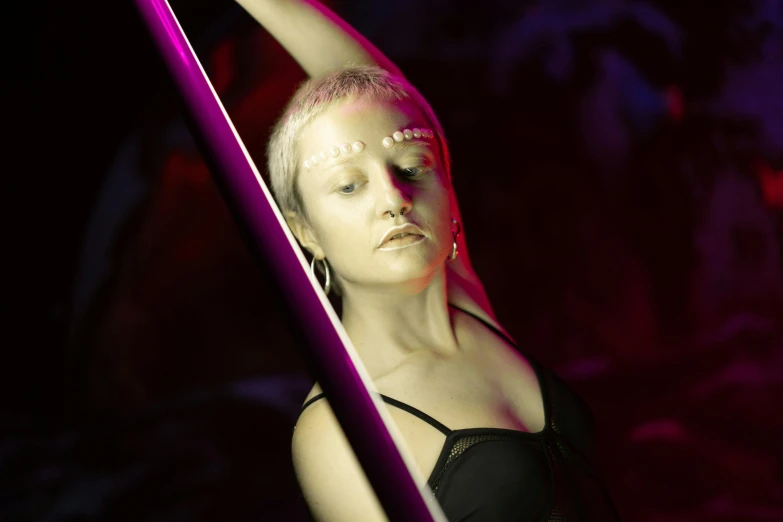 a woman in a black dress holding a pole, a portrait, inspired by Henry Fuseli, unsplash, neo-figurative, soft neon purple lighting, posing in leotard and tiara, intense albino, neon ligh