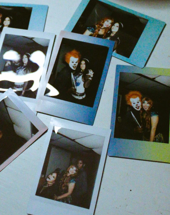 a bunch of polaroids sitting on top of a table, inspired by Nan Goldin, unsplash, holography, pennywise theme, punk party, orange and blue tones, profile image