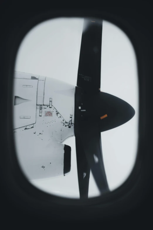 a view of the wing of an airplane through a window, by Jacob Toorenvliet, thrusters, a round minimalist behind, engine, low quality photo