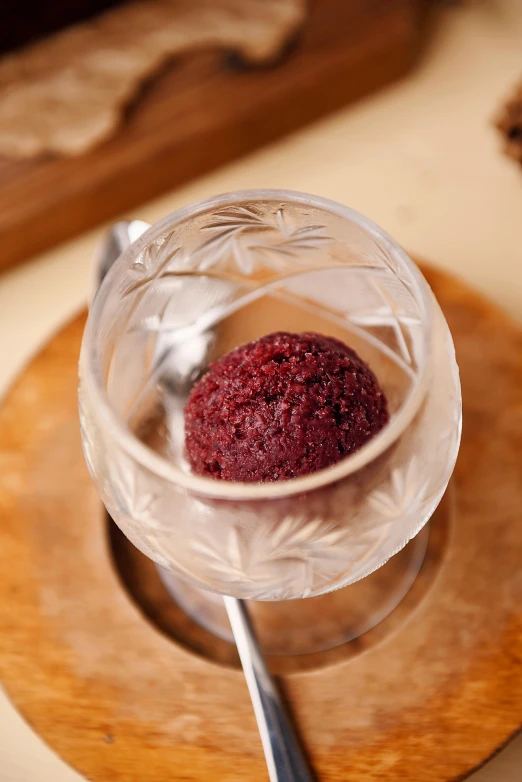 a close up of a bowl of food with a spoon, garnet, slush, on display, medium