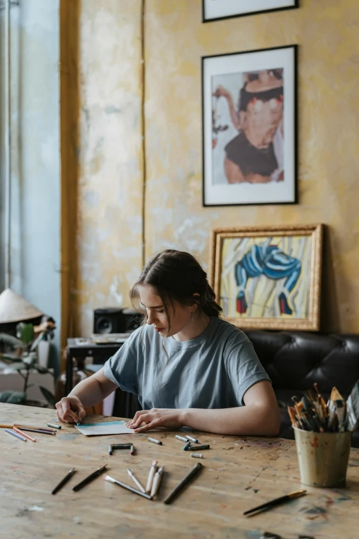 a woman sitting at a table writing on a piece of paper, arbeitsrat für kunst, lachlan bailey, high quality image, on canvas, indi creates