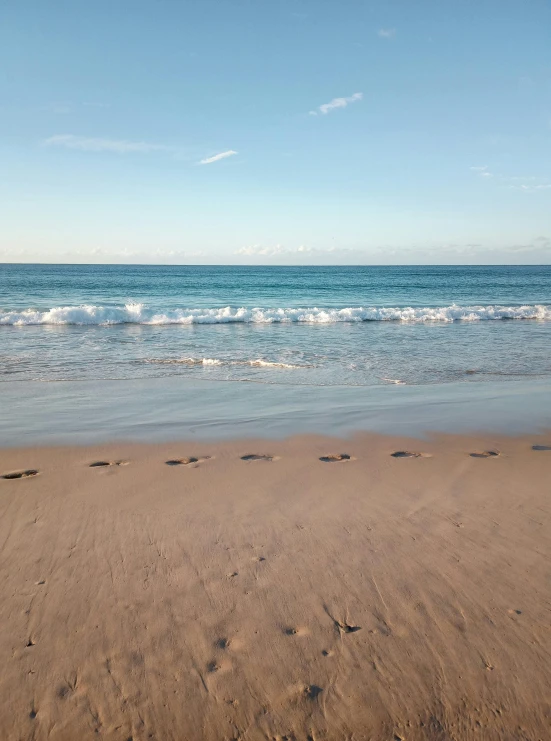 a sandy beach with footprints in the sand, happening, profile image, marbella, day time, view of the ocean