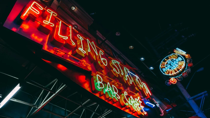 a neon sign hanging from the side of a building, inside a bar, flying souls, living the good life, unsplash photo contest winner