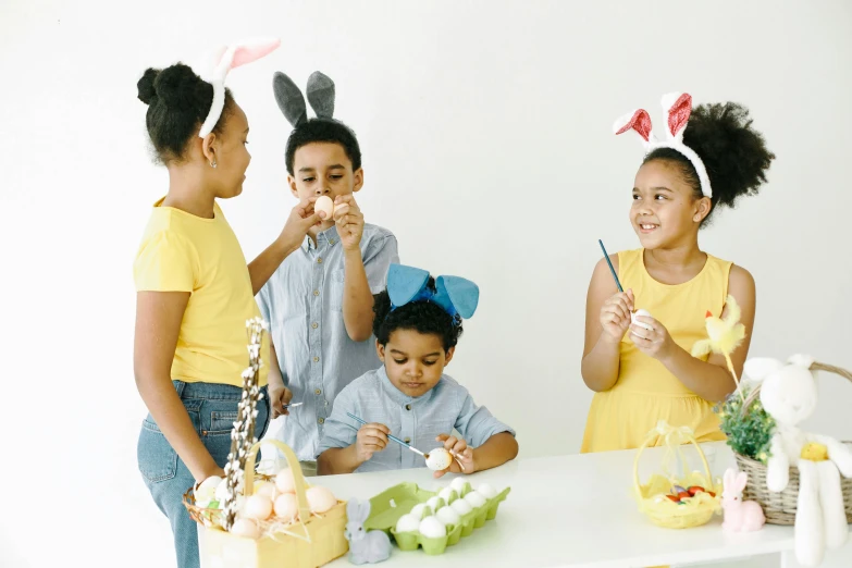 a group of children standing around a table, pexels contest winner, interactive art, bunny ears, crafts and souvenirs, eggs, avatar image