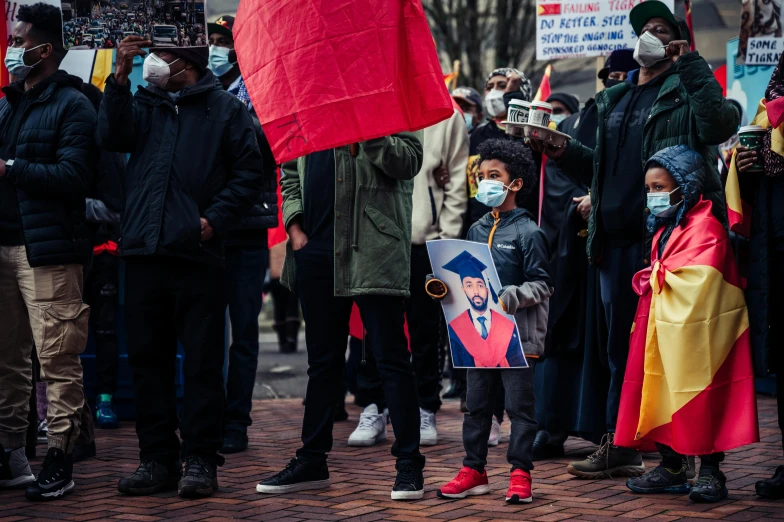 a group of people holding signs and flags, by Julia Pishtar, pexels, realism, red hoods, square, a photo of a man, riyahd cassiem