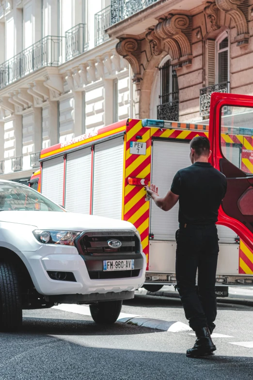 a man standing in front of a fire truck, pexels contest winner, les automatistes, paris, security robots delivery, square, splash image