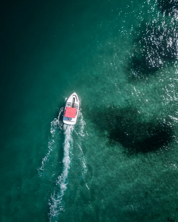 a boat in the middle of a body of water, top down