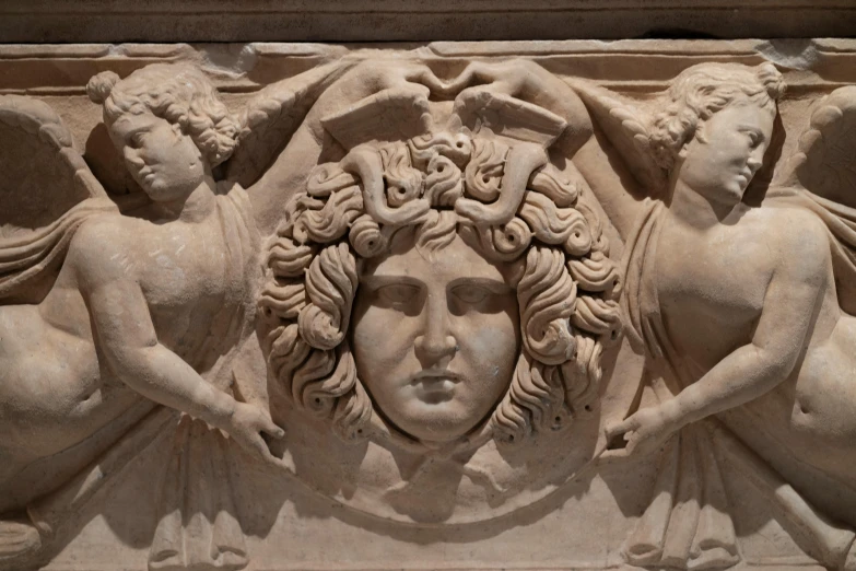 a close up of a statue with angels on it, a marble sculpture, by Luca della Robbia, neoclassicism, the face emerges from pamukkale, with symmetrical head and eyes, single clay museum sculpture, the non-binary deity of spring