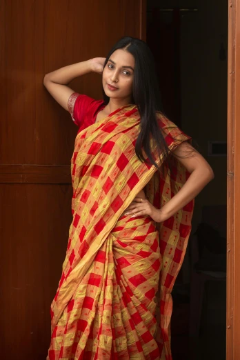 a woman in a red and yellow sari, inspired by T. K. Padmini, hurufiyya, checkered motiffs, promo image, beige, teenager