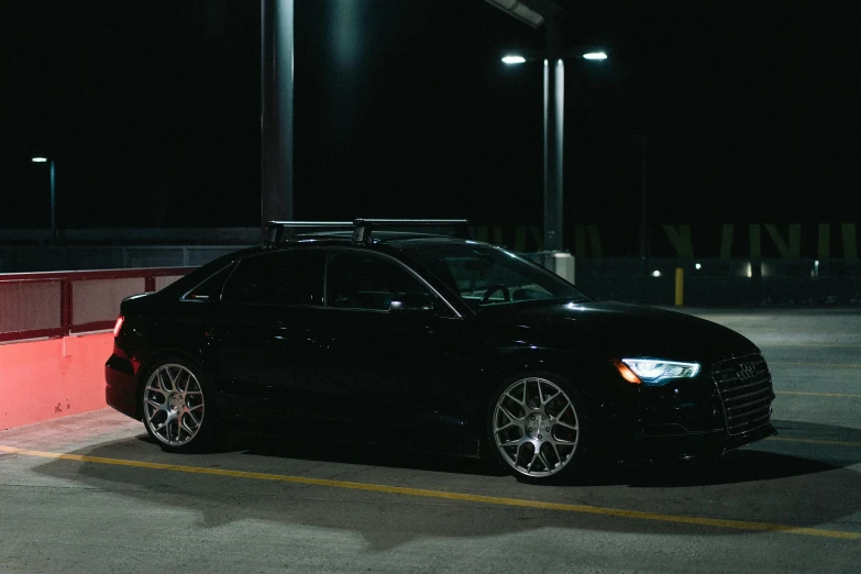 a black audi parked in a parking lot at night, by Drew Tucker, unsplash, purism, with a roof rack, profile posing, ad image, black rims