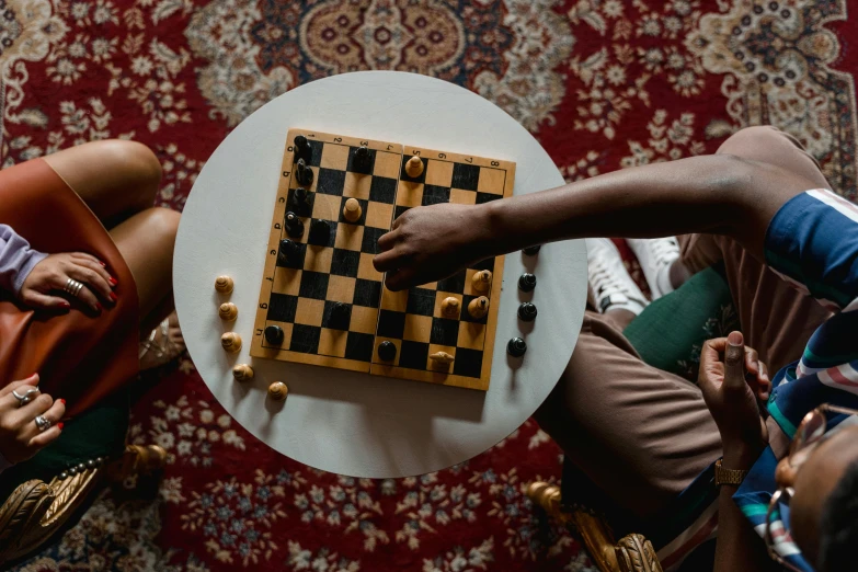 a group of people playing a game of chess, an album cover, by Carey Morris, pexels contest winner, sitting on a mocha-colored table, riyahd cassiem, at home, 15081959 21121991 01012000 4k