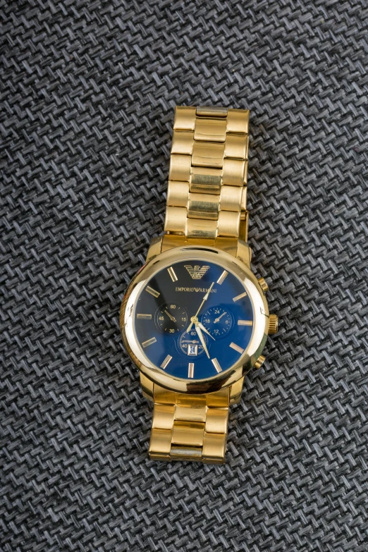 a close up of a watch on a table, a portrait, inspired by Alfredo Volpi, unsplash, golden blue outfit, thumbnail, armani, detailed product image