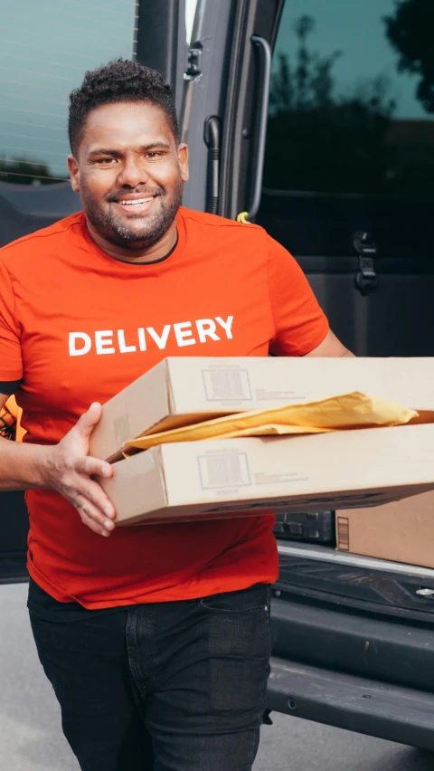 a delivery man holding a box in front of a van, pexels contest winner, hurufiyya, black and orange, wearing a t-shirt, beefy, delete