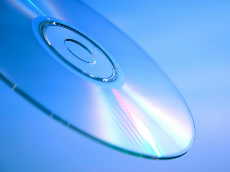 a close up of a disc on a blue background, flickr, xbox, jewel case, transparent glass surfaces, thin dof