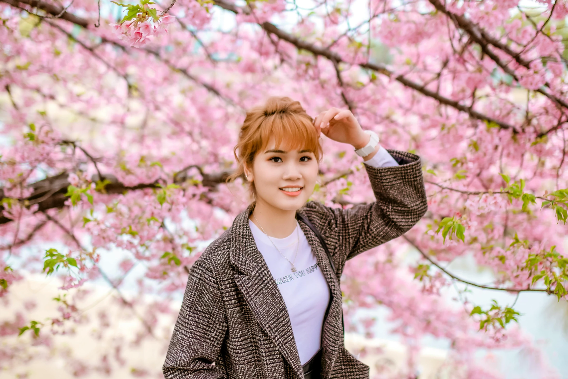 a woman standing under a tree with pink flowers, a picture, inspired by Kim Jeong-hui, pexels contest winner, shin hanga, brown reddish hair, wearing jacket, avatar image, lalisa manobal