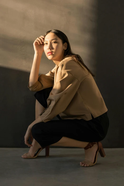 a woman sitting on a chair in a room, inspired by Kim Tschang Yeul, trending on pexels, wear's beige shirt, at a fashion shoot, sitting on bench, soft shadow