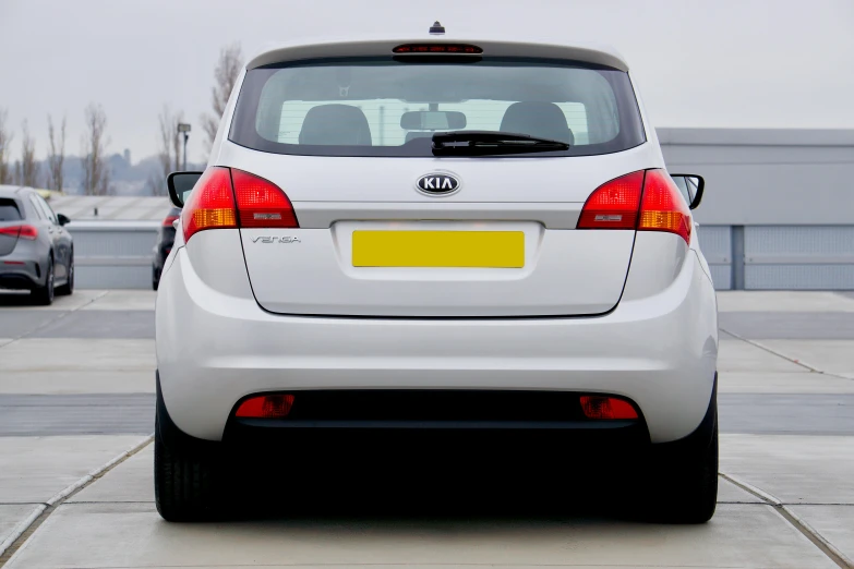 a white car parked in a parking lot, by John Henderson, pexels contest winner, rear view, square, kia soul, cross hatch