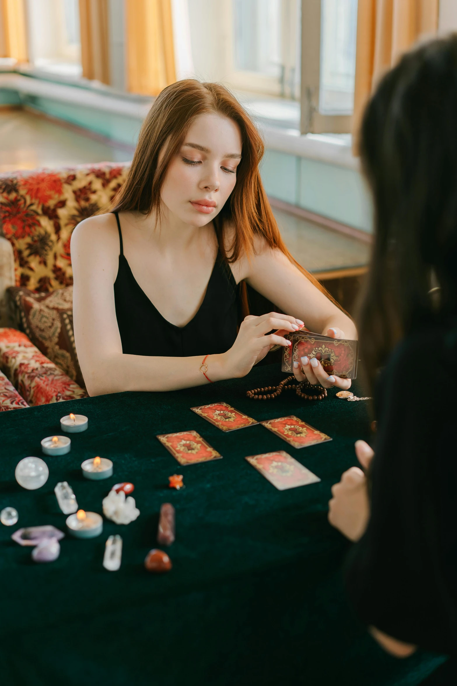 two women sitting at a table playing cards, by Julia Pishtar, trending on pexels, dressed as an oracle, selling a gem, inspect in inventory image, woman with braided brown hair