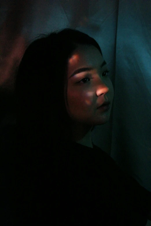 a woman looking at a cell phone in the dark, an album cover, inspired by Elsa Bleda, reddit, realism, 🤤 girl portrait, dark. studio lighting, a young asian woman, portrait sophie mudd